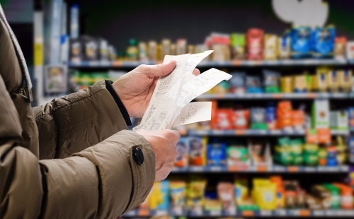 Person examining receipts in a supermarket